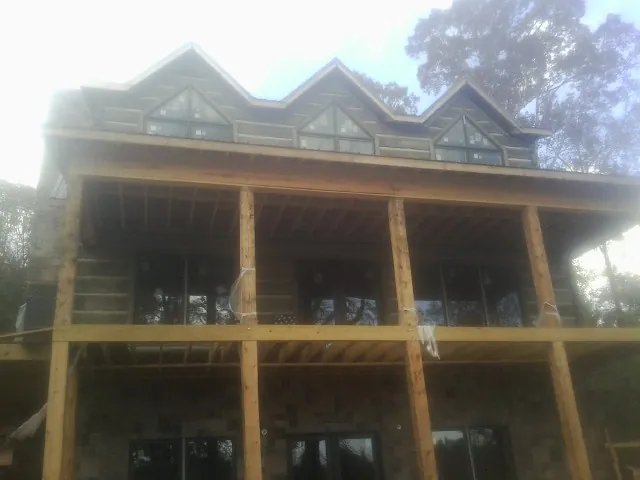 Dormers and porch framing on a large log home under construction — Roof Coating work by our crew in Beaver